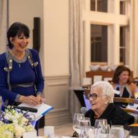 President Mantella smiling at event guest while she asks question to panelists